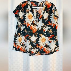 Short-sleeved blouse with orange and white flowers.